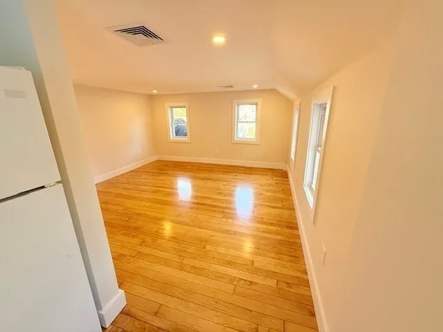 a view of empty room with wooden floor and cabinet