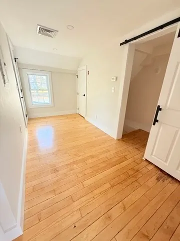 an empty room with wooden floor and a window