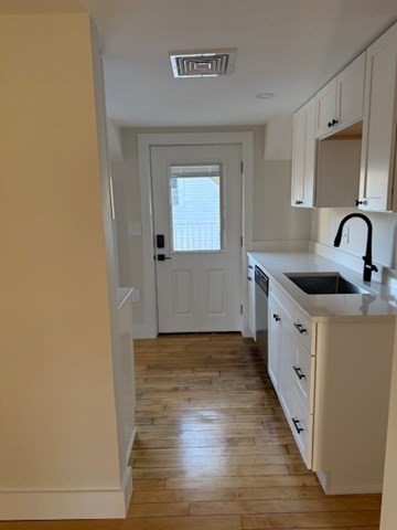 244 Main Street, Unit 2 North Andover, MA 01845 - Photo 6 of 36 a kitchen with granite countertop a sink and a stove top oven
