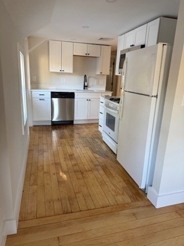 244 Main Street, Unit 2 North Andover, MA 01845 - Photo 7 of 36 a kitchen with white cabinets and white appliances