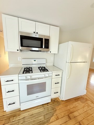 244 Main Street, Unit 2 North Andover, MA 01845 - Photo 8 of 36 a white kitchen with a stove and a microwave