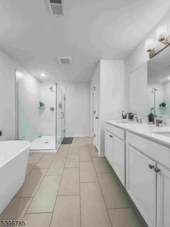 a bathroom with a double vanity sink a toilet and a bathtub