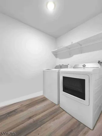 a view of an empty room with wooden floor and fireplace