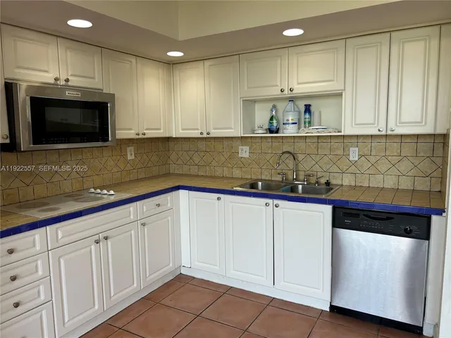 a kitchen with stainless steel appliances granite countertop a sink a stove and cabinets