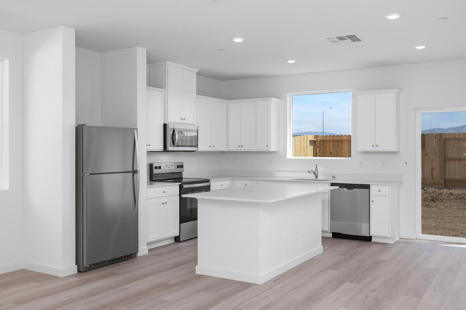 820 Helmsley Lane Patterson, CA 95363 - Photo 5 of 18 a kitchen with a refrigerator stove and wooden cabinets