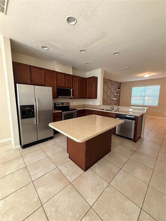7843 Hardenton Street Windermere, FL 34786 - Photo 11 of 19 a kitchen with stainless steel appliances a stove a sink a microwave and a refrigerator