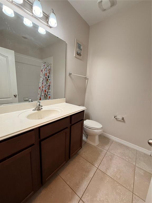 7843 Hardenton Street Windermere, FL 34786 - Photo 16 of 19 a bathroom with a sink a toilet a mirror and vanity