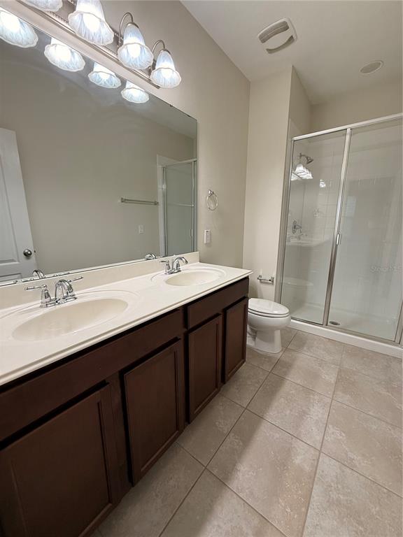 7843 Hardenton Street Windermere, FL 34786 - Photo 18 of 19 a spacious bathroom with a double vanity sink a large mirror and a shower