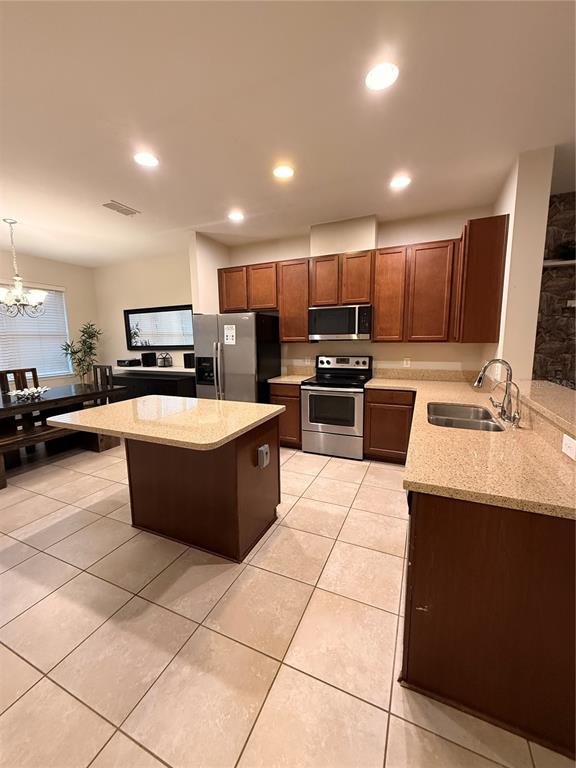 7843 Hardenton Street Windermere, FL 34786 - Photo 3 of 19 a large kitchen with kitchen island a stove a sink a counter top and living room view