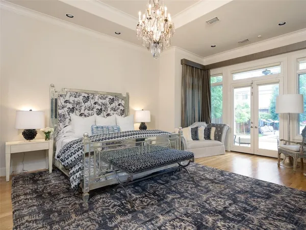 a spacious bedroom with a large bed and a chandelier