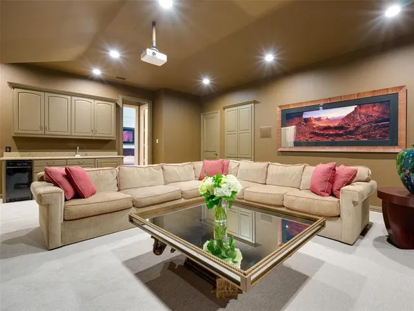 a living room with furniture a table and kitchen view