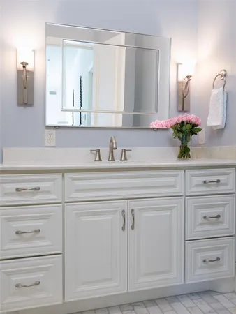 a bathroom with white cabinets and a sink