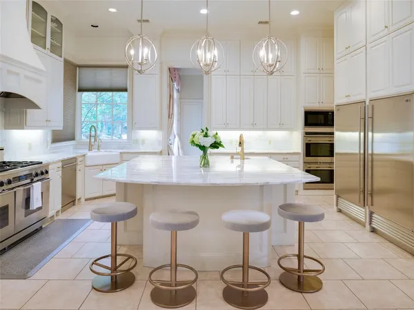 a kitchen with stainless steel appliances granite countertop a sink a stove a counter space and cabinets
