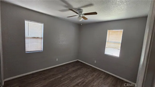 an empty room with a window and a ceiling fan