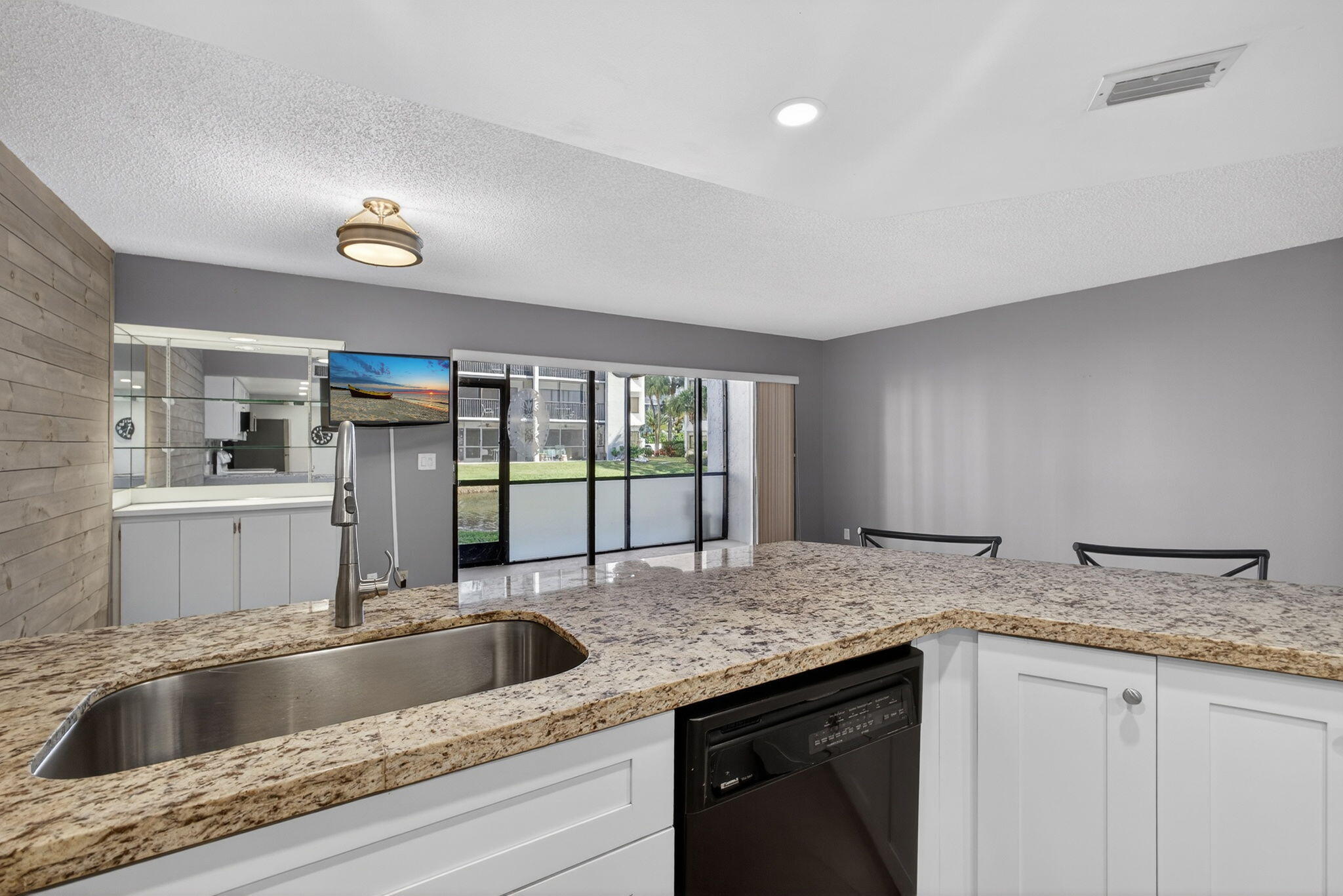 1605 Highway 1, Unit D105 Jupiter, FL 33477 - Photo 20 of 69 a kitchen with granite countertop a sink and a wooden floor