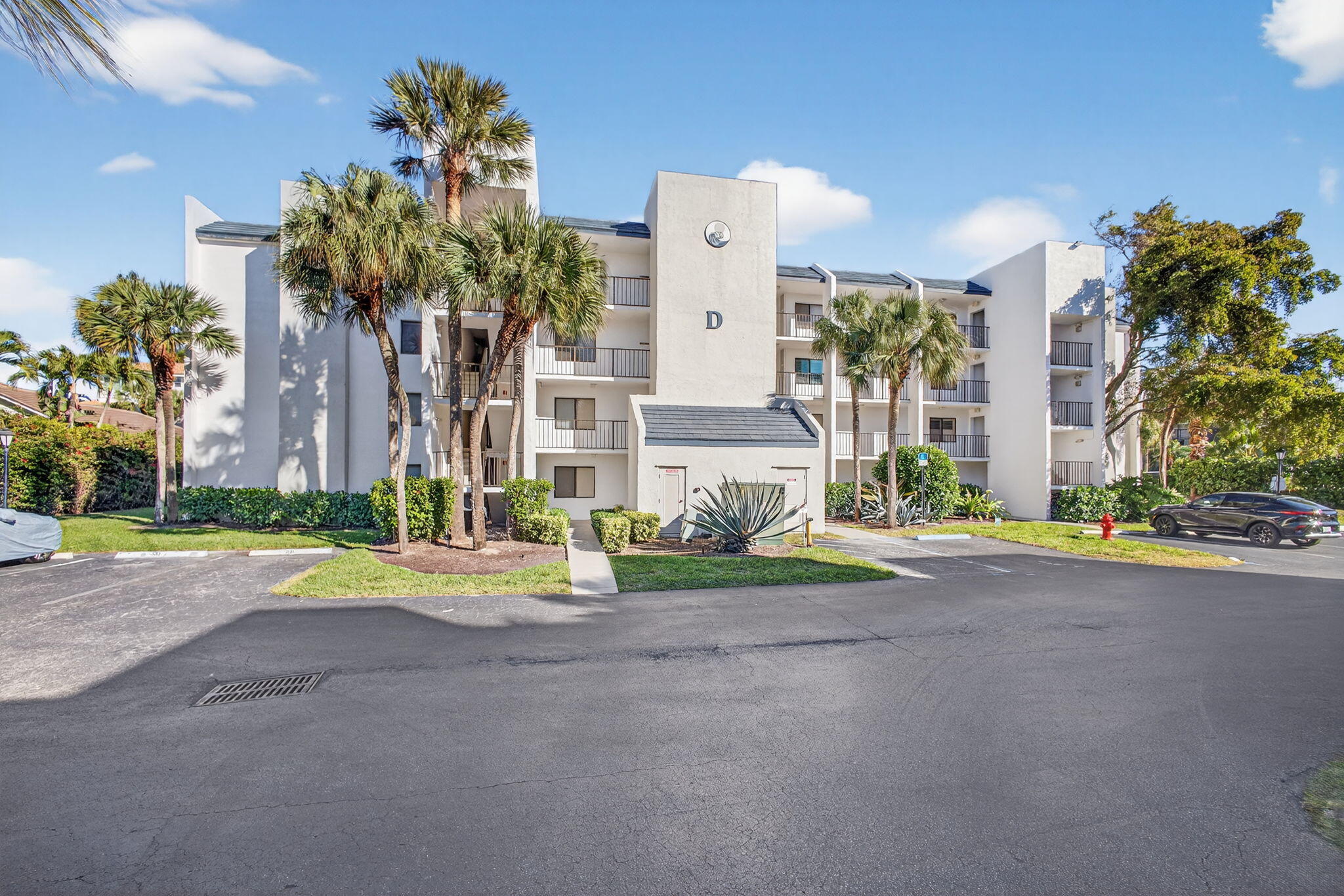 1605 Highway 1, Unit D105 Jupiter, FL 33477 - Photo 40 of 69 a front view of a house with a yard and outdoor seating