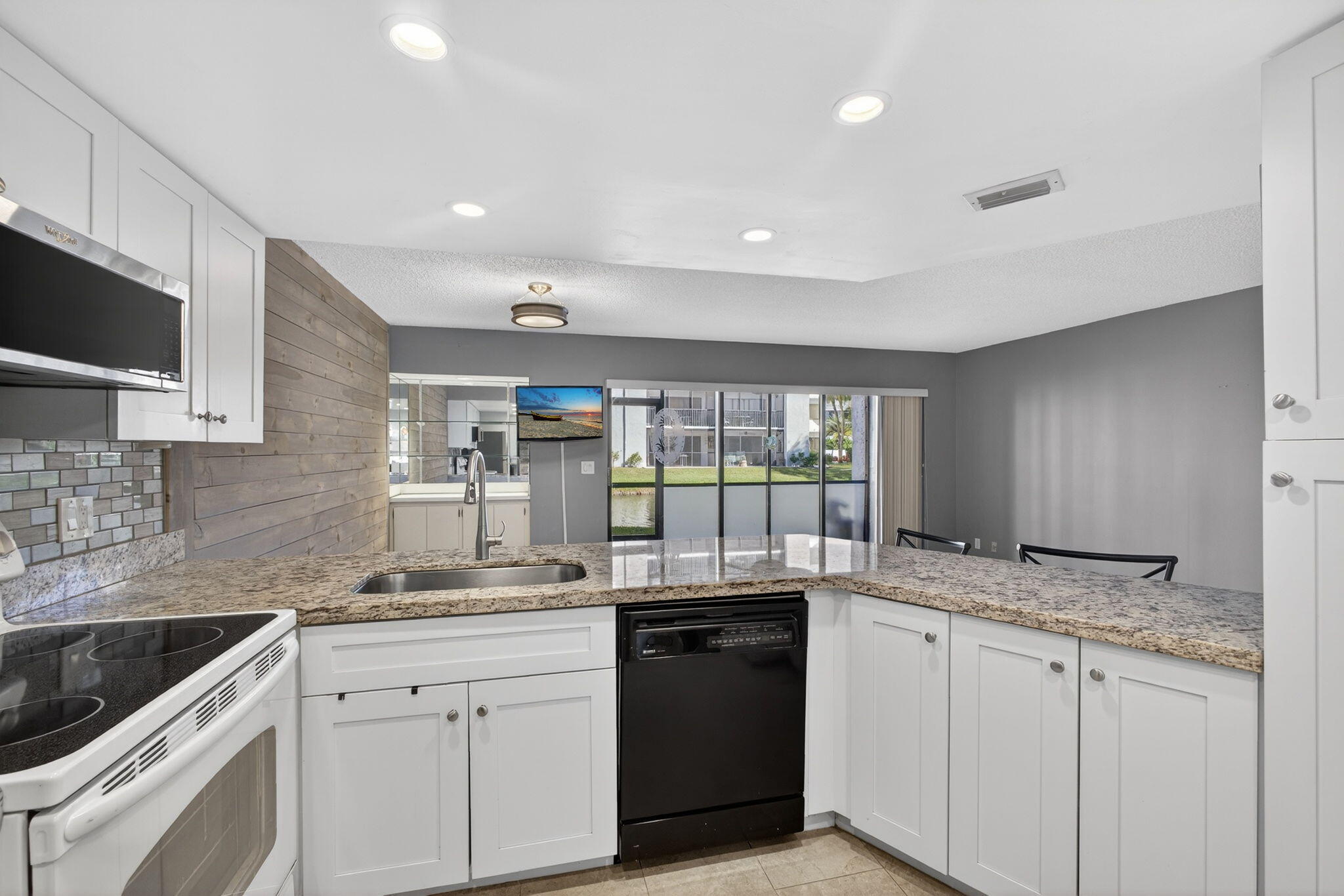1605 Highway 1, Unit D105 Jupiter, FL 33477 - Photo 9 of 69 a kitchen with granite countertop sink stainless steel appliances and cabinets