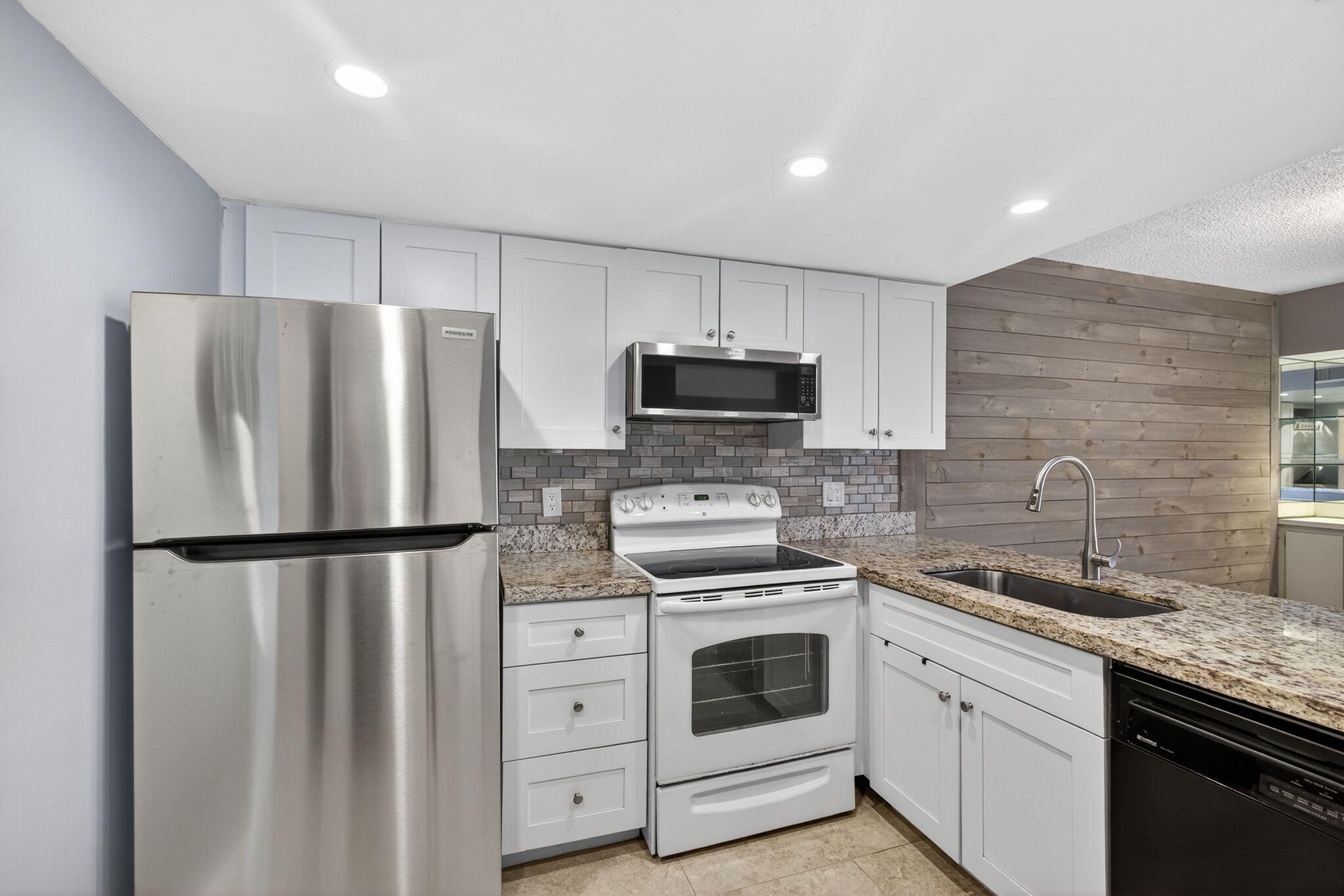 1605 Highway 1, Unit D105 Jupiter, FL 33477 - Photo 10 of 69 a kitchen with a refrigerator sink and white cabinets