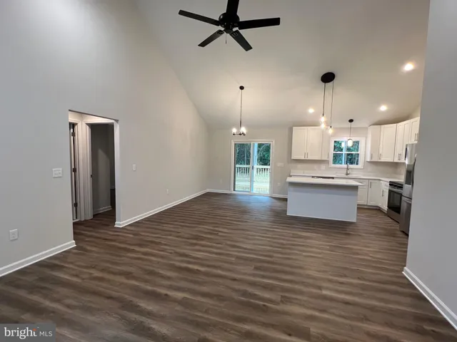 a large kitchen with a refrigerator a stove a sink dishwasher and a oven with wooden floor