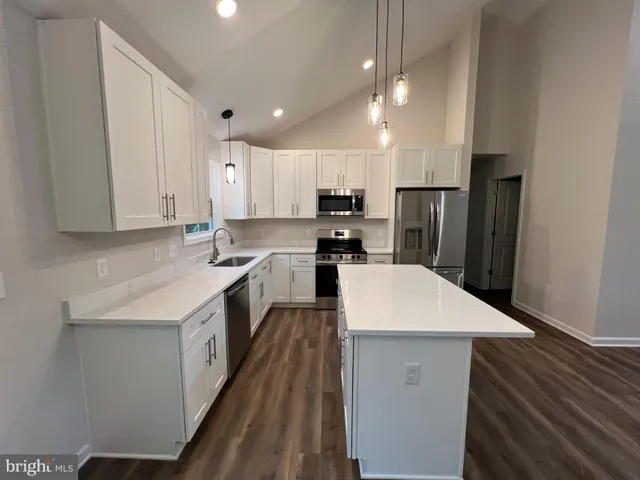 a view of a kitchen with a sink and wooden floor
