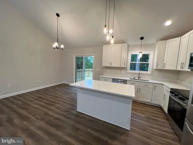 a view of a kitchen with stove and wooden floor