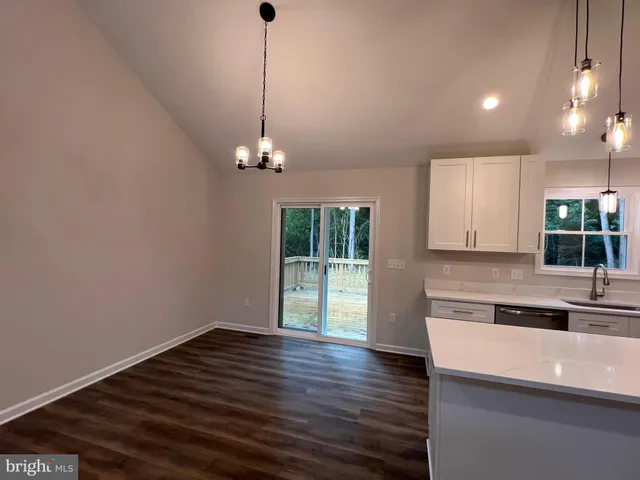 a kitchen with stainless steel appliances granite countertop a refrigerator a stove a sink dishwasher and a refrigerator with wooden floor