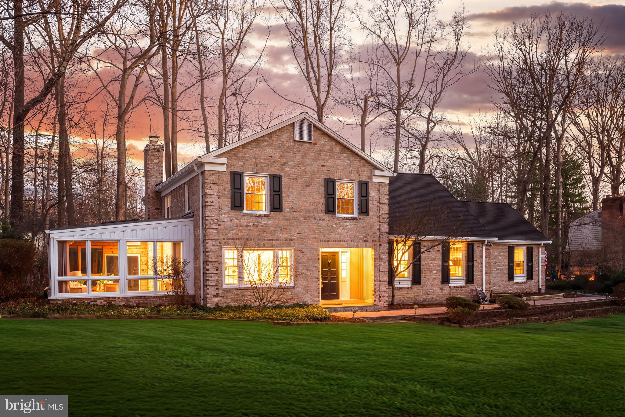 a front view of a house with a garden and trees