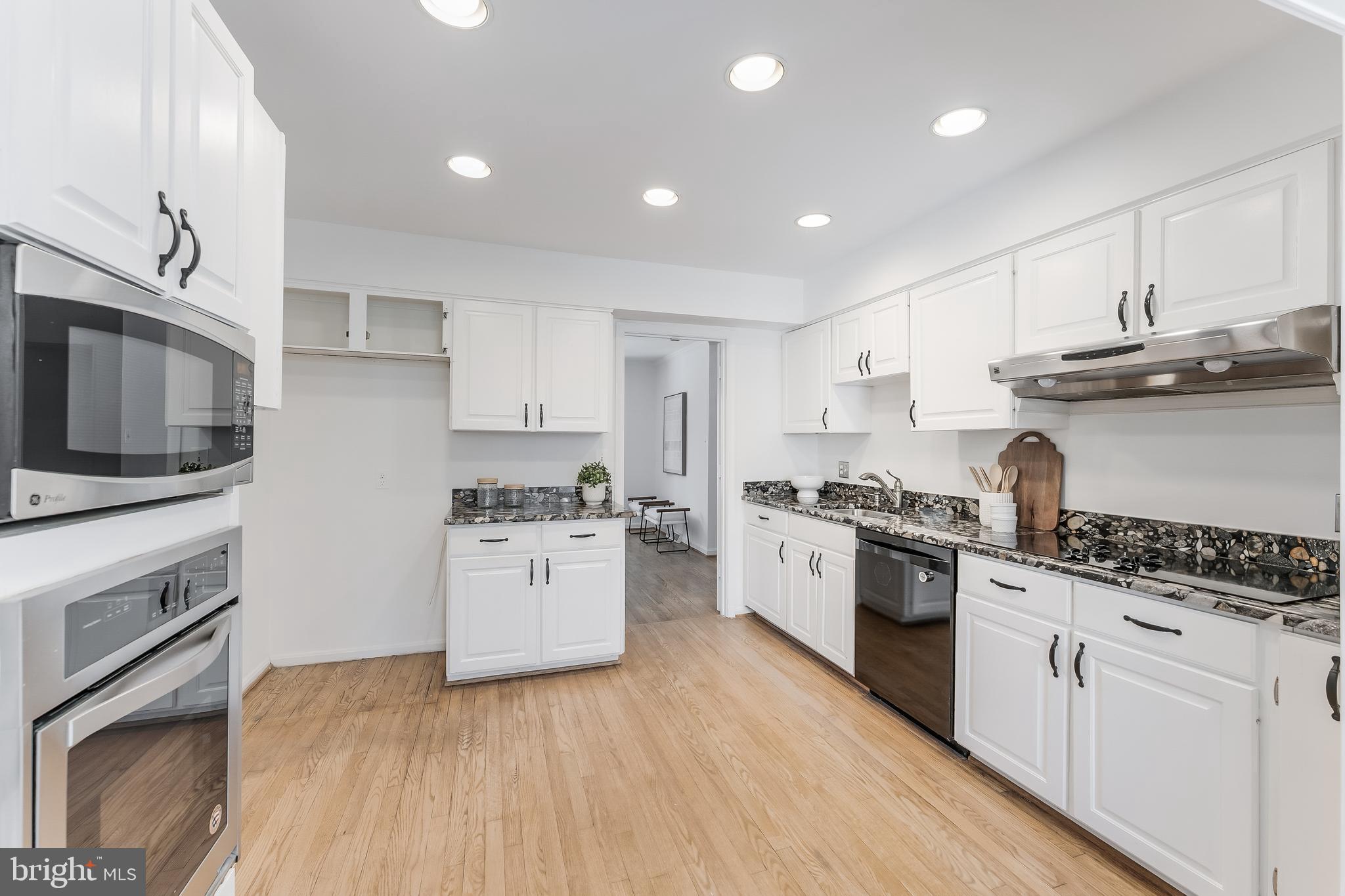 2615 Steeplechase Drive Reston, VA 20191 - Photo 33 of 79 a kitchen with stainless steel appliances granite countertop a stove top oven a sink dishwasher a refrigerator and white cabinets with wooden floor
