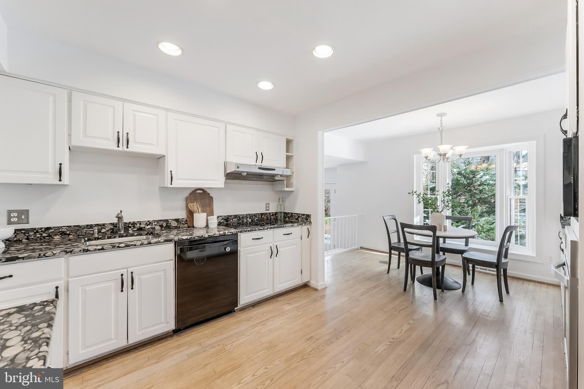 2615 Steeplechase Drive Reston, VA 20191 - Photo 35 of 79 a kitchen with granite countertop stainless steel appliances a dining table chairs stove and white cabinets