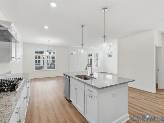 a kitchen with kitchen island a sink stove and wooden floor