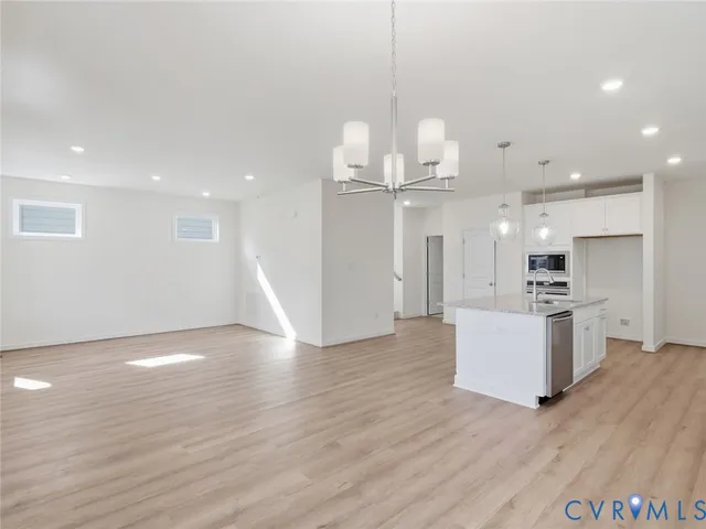a view of a kitchen with a sink stainless steel appliances and wooden floor