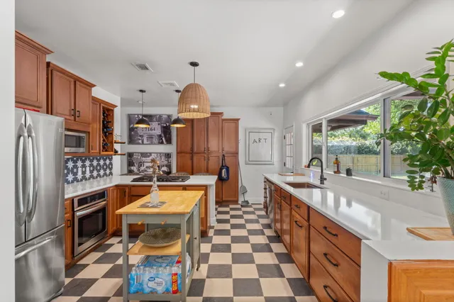 a kitchen with stainless steel appliances granite countertop a sink and a refrigerator
