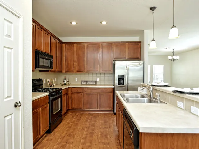a kitchen with a sink stove top oven and refrigerator