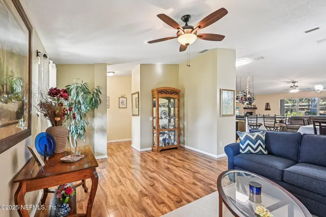 a view of a dining room and livingroom with furniture a rug a fireplace and a chandelier