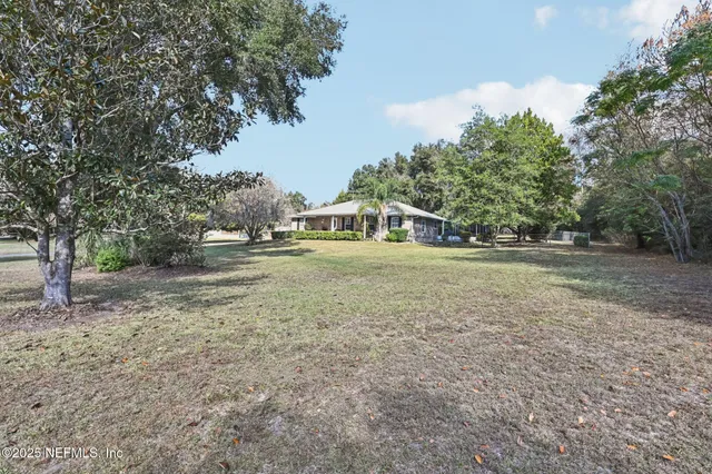 a view of a house with backyard and sitting area