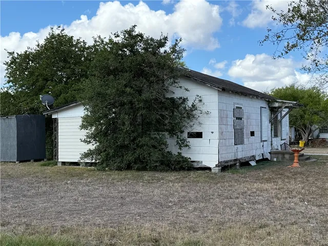 a wooden house with trees in front of it