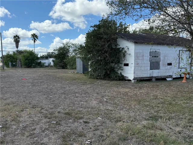 a view of a backyard with potted plants and large trees