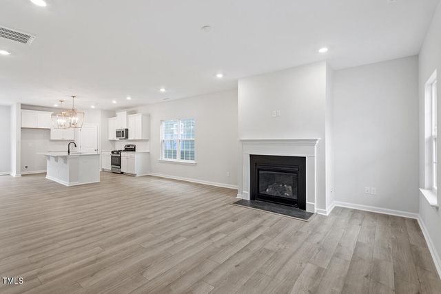 a view of a livingroom with a fireplace a ceiling fan and window