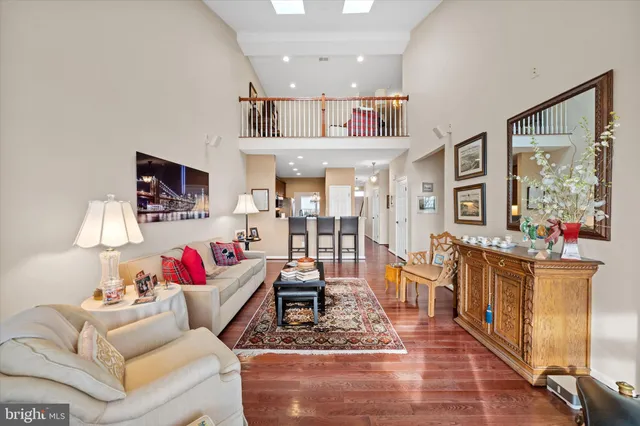 a kitchen with stainless steel appliances granite countertop a stove top oven a sink a dining table and chairs with wooden floor