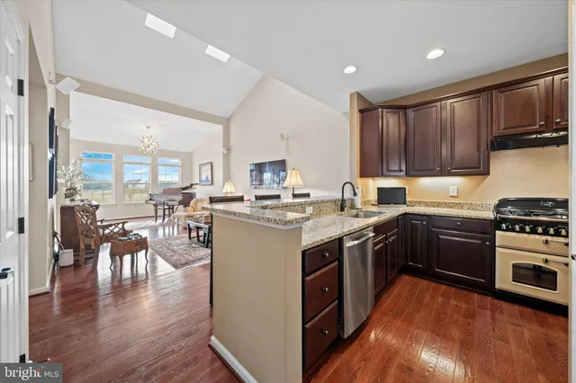 a kitchen with stainless steel appliances granite countertop a stove refrigerator sink and cabinets