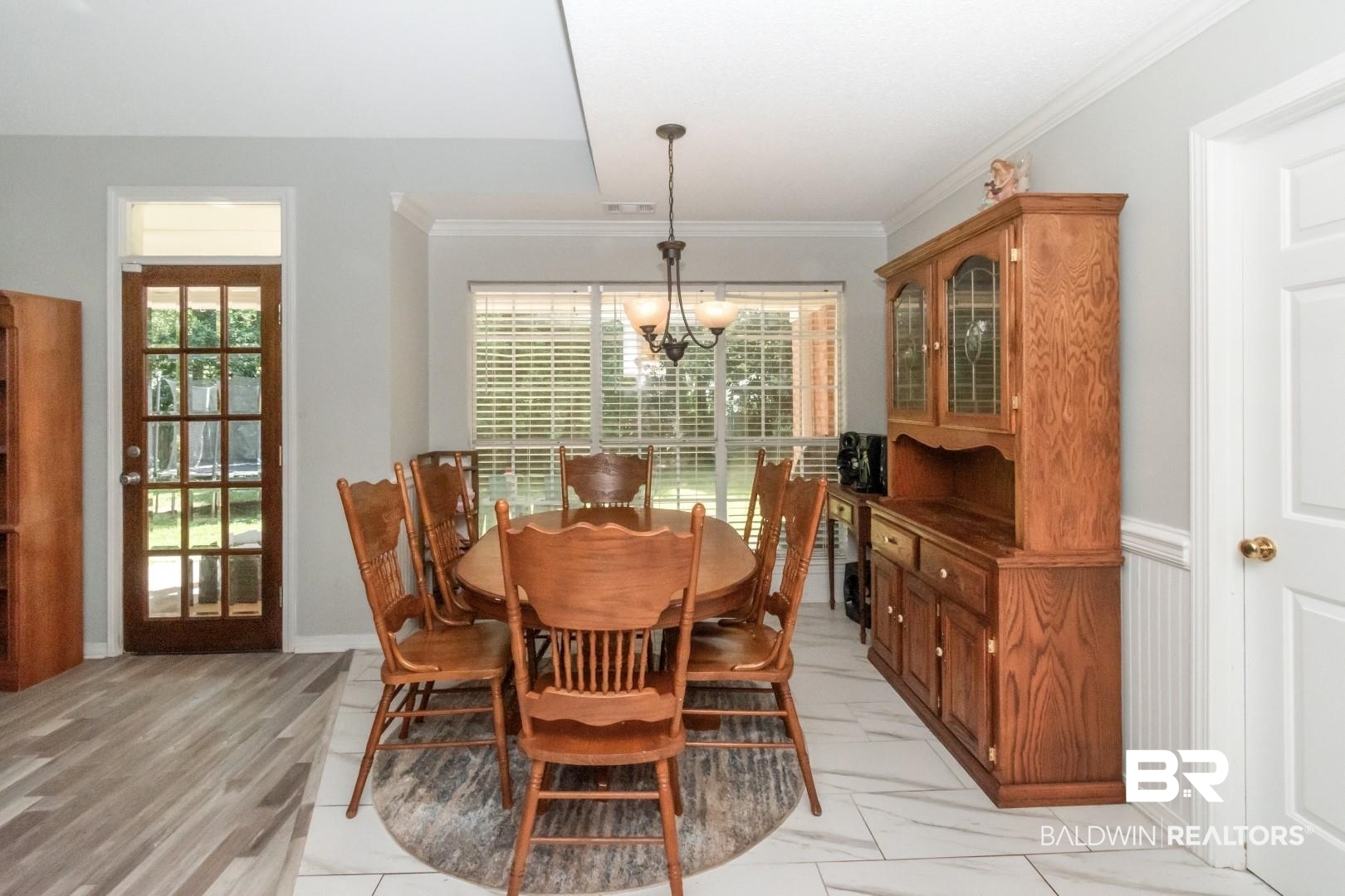9991 Wedgefield Court Mobile, AL 36608 - Photo 10 of 30 Dining space with ornamental molding, light tile patterned floors, and an inviting chandelier