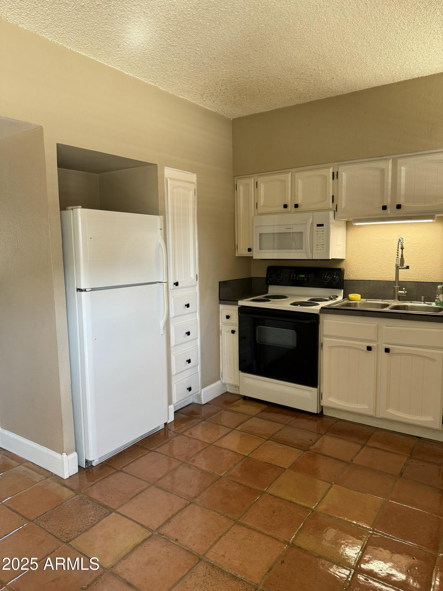 349 East Thomas Road, Unit E207 Phoenix, AZ 85004 - Photo 11 of 13 a kitchen with stainless steel appliances a stove a sink and a refrigerator