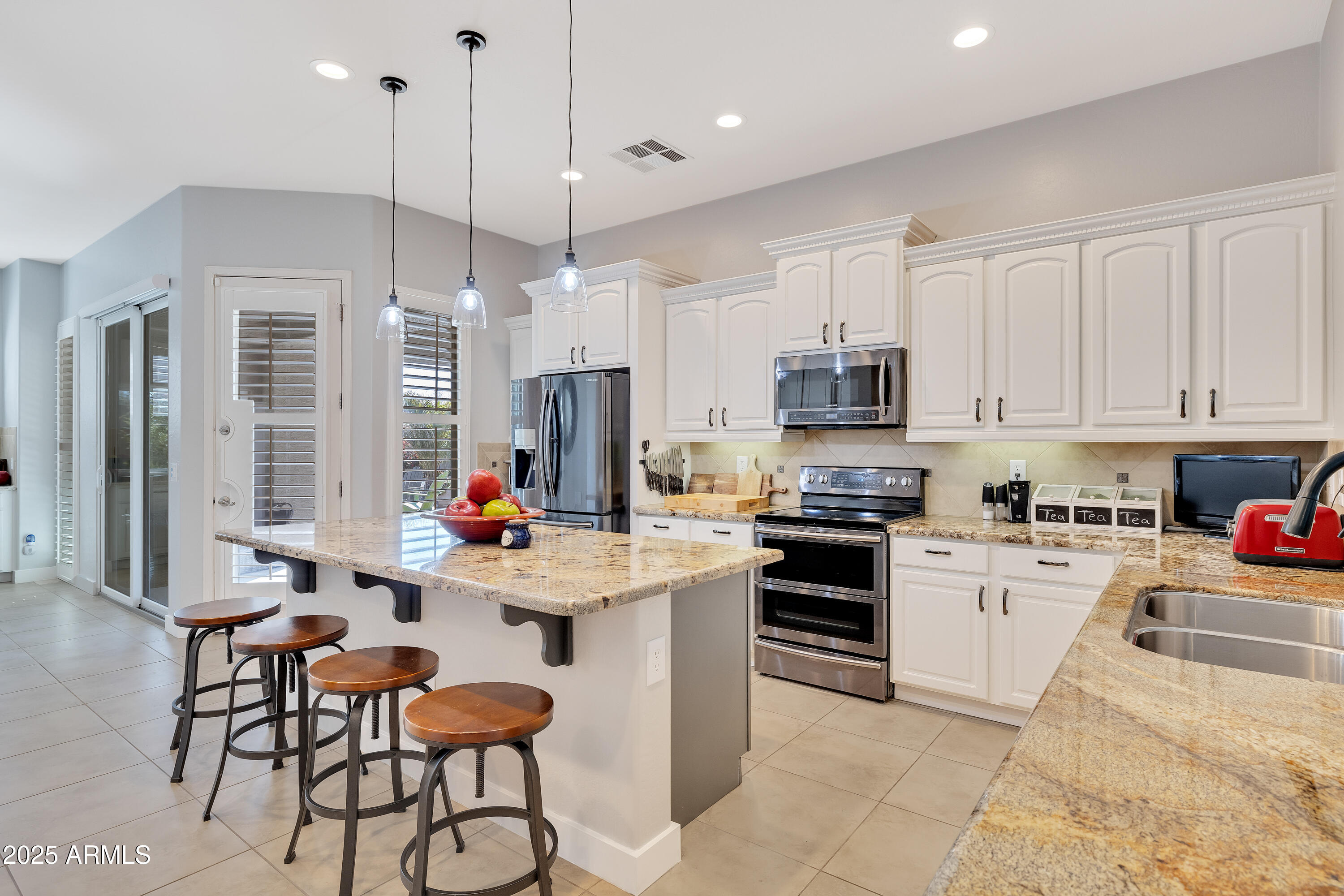 16896 North Palo Rojo Road Maricopa, AZ 85138 - Photo 12 of 48 a kitchen with stainless steel appliances kitchen island granite countertop a stove and cabinets