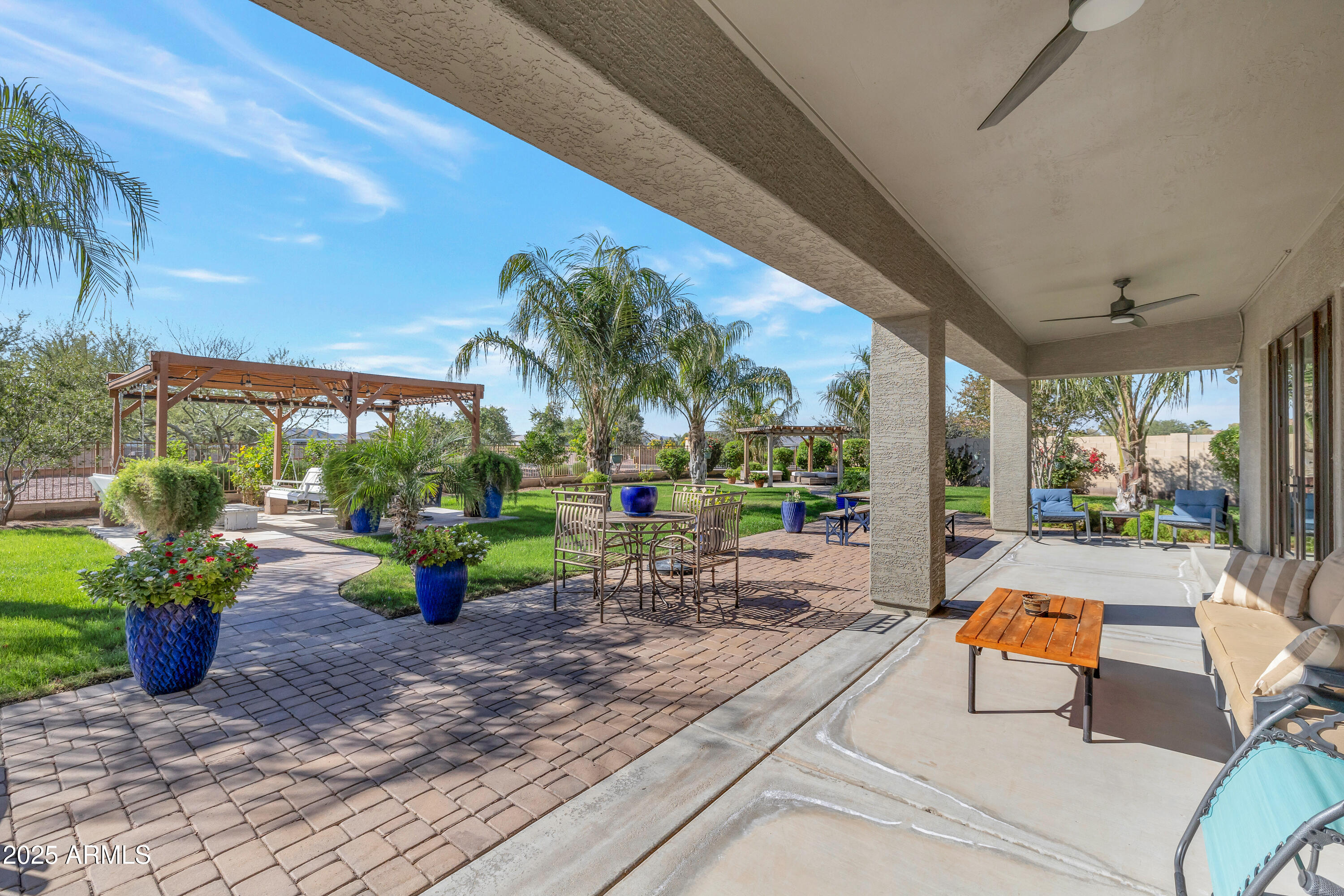16896 North Palo Rojo Road Maricopa, AZ 85138 - Photo 31 of 48 a view of a patio with a dining table and chairs potted plants