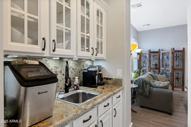 a kitchen that has a sink and a stove with wooden floor
