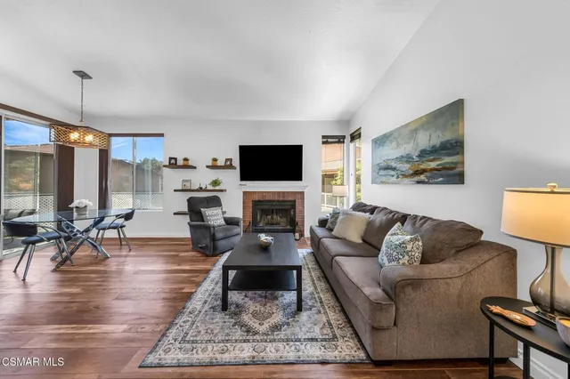 a living room with furniture a rug a fireplace and a flat screen tv