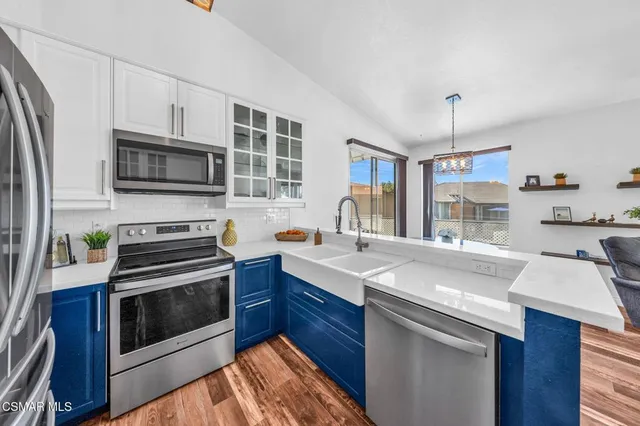 a kitchen with stainless steel appliances granite countertop a refrigerator and a cabinets