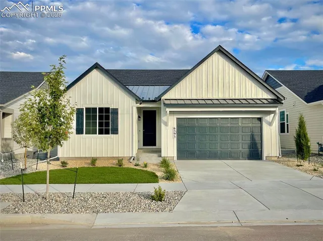 a front view of a house with a garden and garage