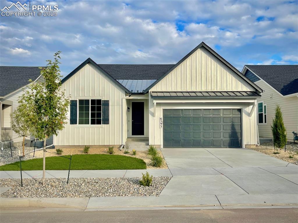 6593 Vistancia Avenue Colorado Springs, CO 80922 - Photo 1 of 21 a front view of a house with a garden and garage