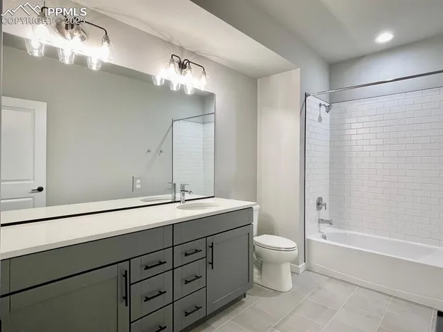 a spacious bathroom with a double vanity sink toilet mirror and bathtub